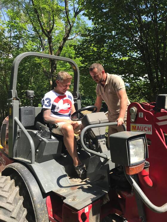 Andi Knoll is sitting on a tractor at Tierwelt Herberstein